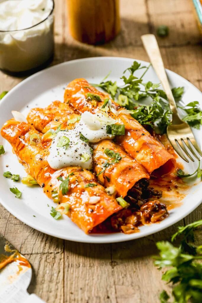Ground beef enchiladas with melted cheese in a baking dish