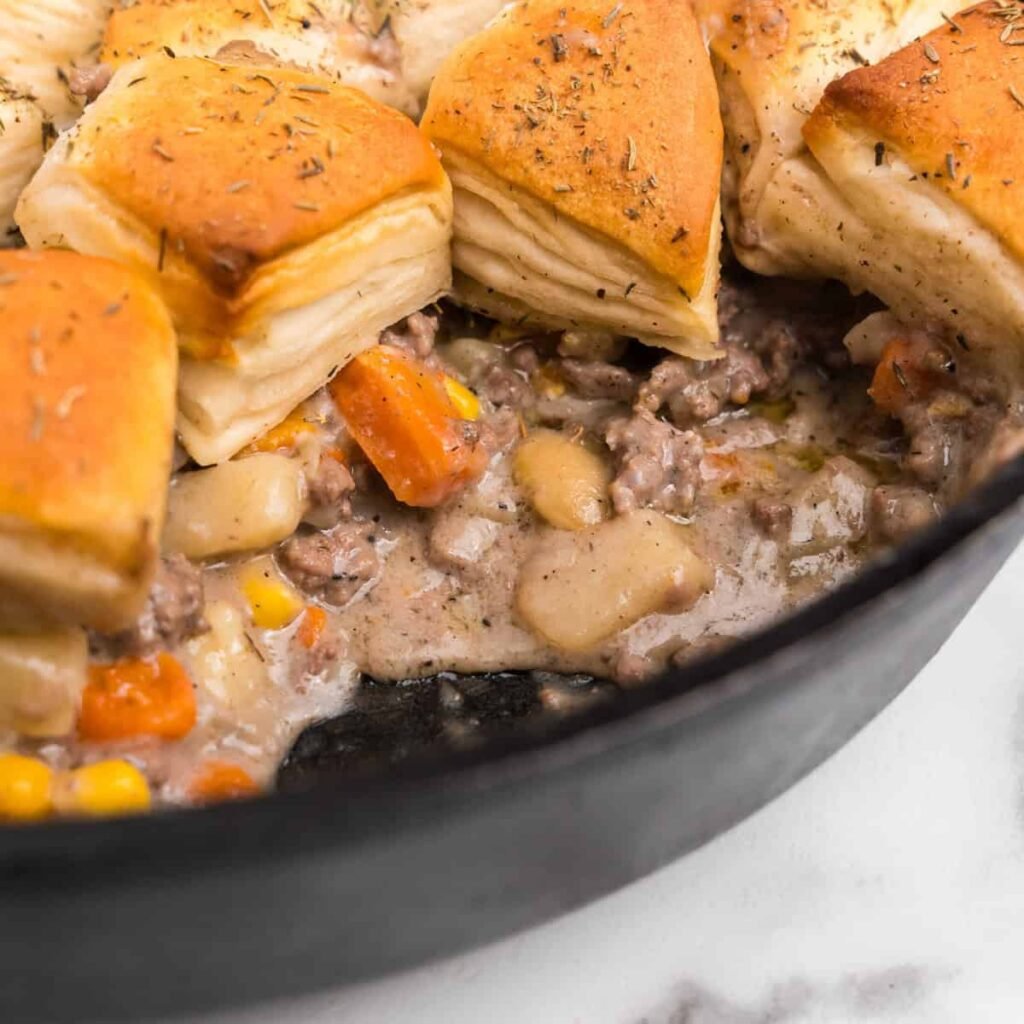 Skillet ground beef pot pie topped with golden biscuits