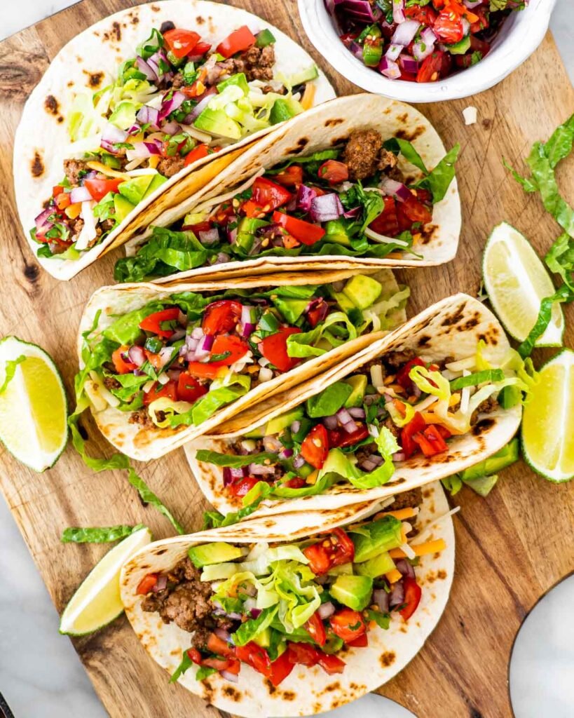 Ground beef tacos with lettuce, cheese and pico de gallo