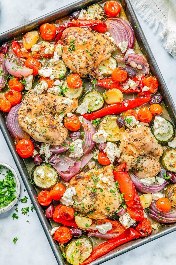 Greek sheet pan chicken with tomatoes, zucchini and peppers